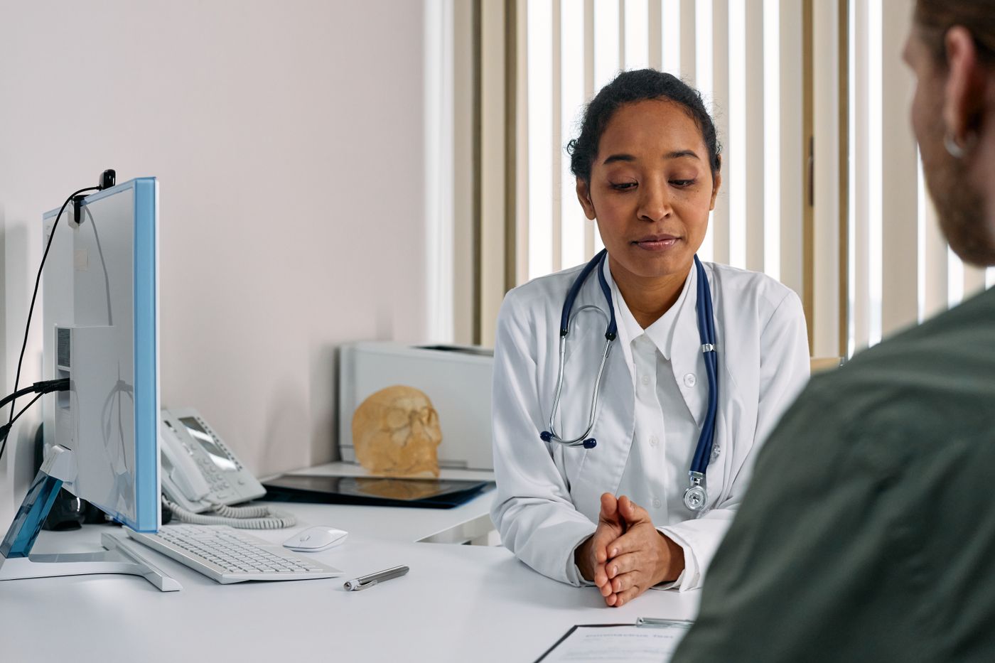 A woman in a warm clinical setting, mid-conversation.